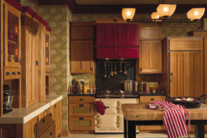 Rustic country kitchen with natural wood cabinetry, red upper cabinets, farmhouse range, and vintage-style decor.