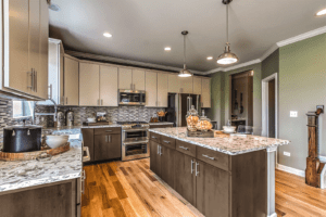 Contemporary kitchen with two-tone cabinetry, granite countertops, pendant lighting, and a large central island.