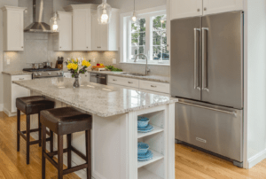 Transitional kitchen with white cabinetry, stainless steel appliances, granite countertops, and a central island with bar seating.