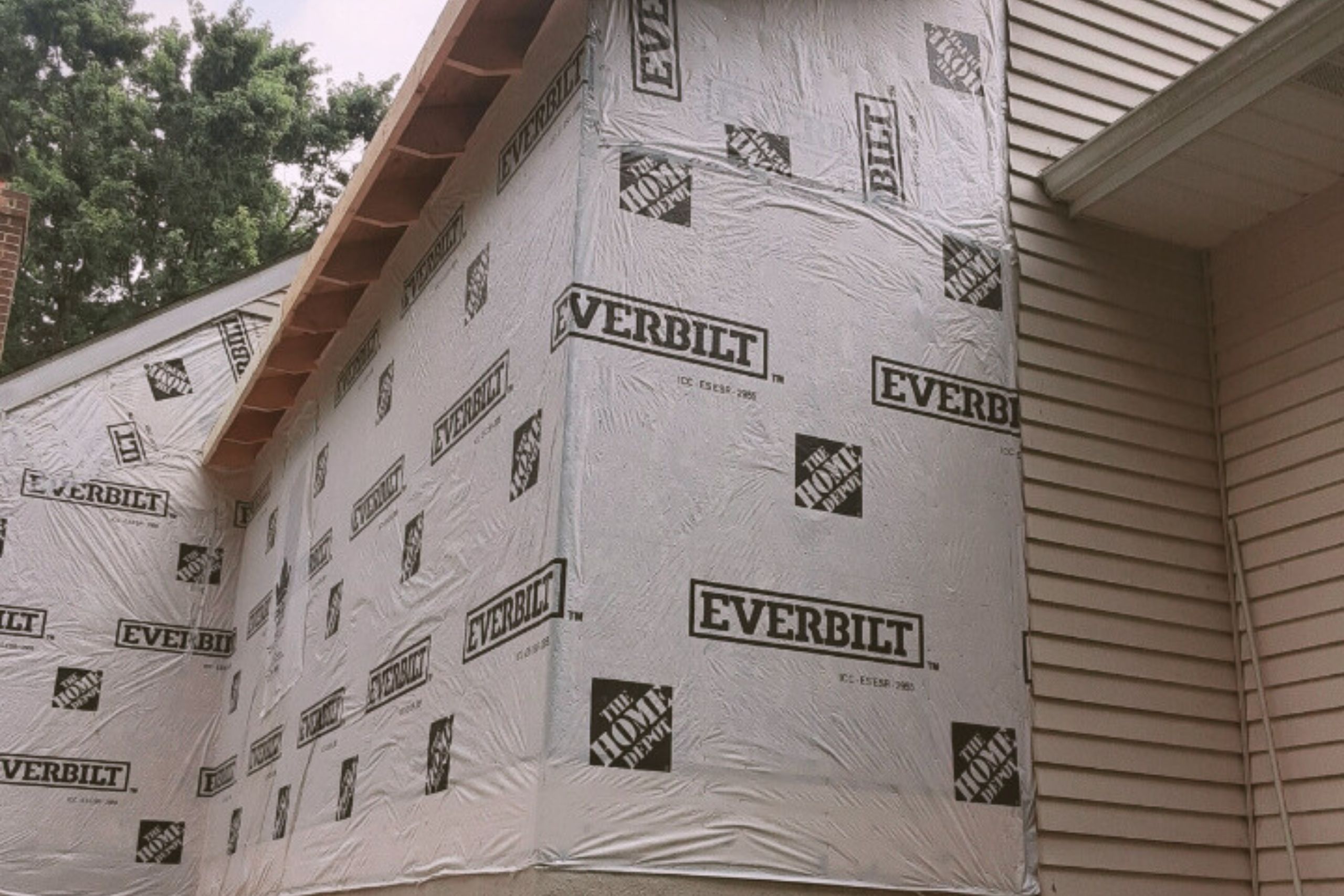 Exterior view of a home under construction, showcasing a bump-out addition wrapped in Everbilt weather-resistant sheathing.