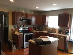 Before photo of a dated kitchen with builder-grade cabinetry, limited lighting, and minimal workspace in Columbia, MD.
