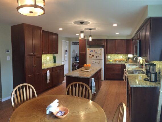 A kitchen with brown cabinets and white counters