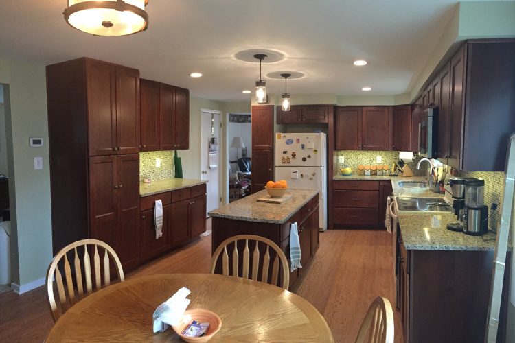 A kitchen with brown cabinets and white counters