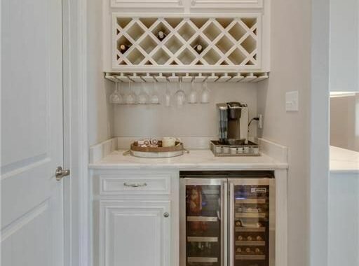 A wine cellar with a mini fridge and cabinets.