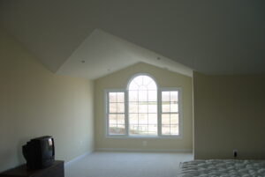 Interior view of master bedroom suite with large arched window