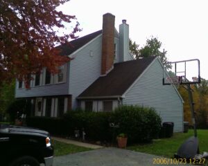 Two-story home with blue vinyl siding and a brick chimney, located in Westminster, Carroll County, Maryland.