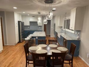 A dining room table and chairs in the center of a kitchen.