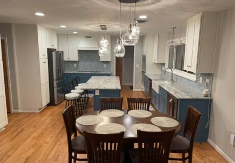 A dining room table and chairs in the center of a kitchen.