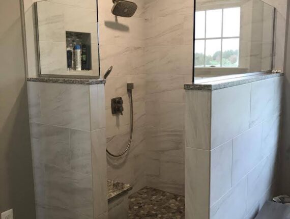 A bathroom with a walk in shower and tiled walls.