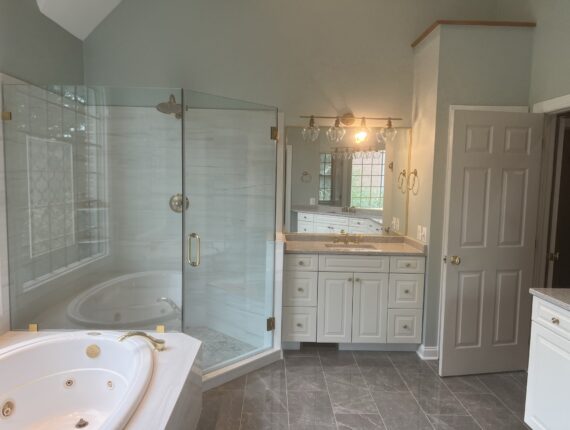 A bathroom with a tub, shower and sink.