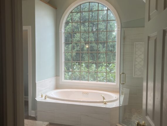 A large white tub sitting in the middle of a bathroom.