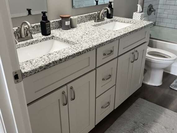 A bathroom with two sinks and a toilet.